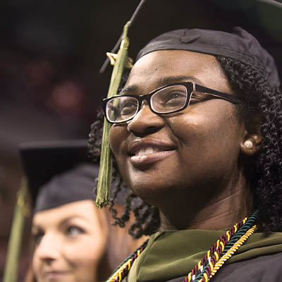 Smiling student in a graduation cap and gown.