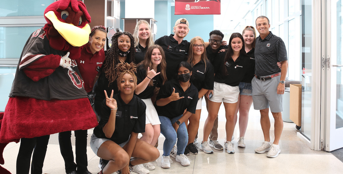 Student staff workers stand with Coach Beamer head Coach of the USC football team in the Patterson residence hall.