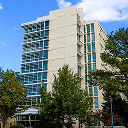 Patterson Hall residence hall front entrance as the sun rises to the left of the building.