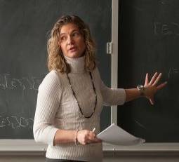 Adjunct faculty stadning at chalk board, teaching a class