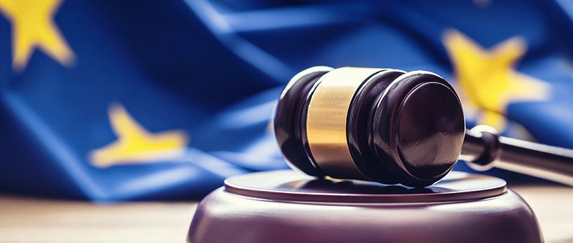 Judge's gavel resting in front of the flag of the International Criminal Court