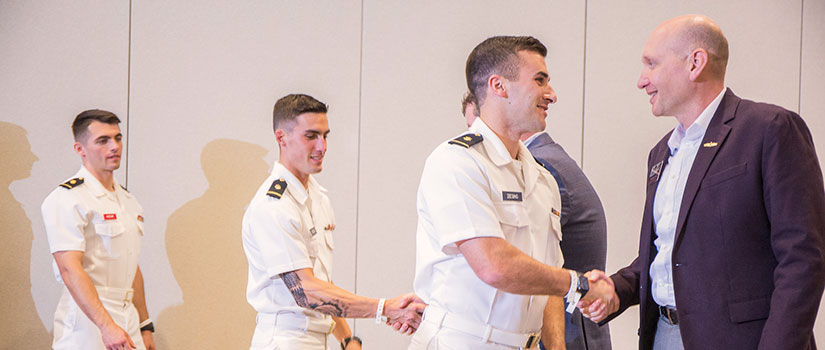 students in uniform shaking hands with mentors