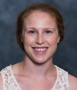 Allison wears a white lace tank top and smiles at the camera