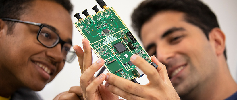 two students hold large computer chip