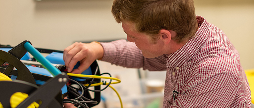 male student works on a robot