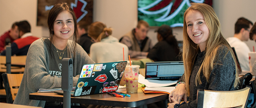 two female students sit in the cafe together