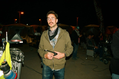 Phillips with walkie talkie in hand on a film set during the night.