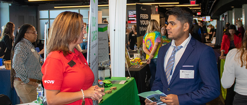 A CVS recruiter speakers with an HRSM student at the fall 2022 Experience Expo.