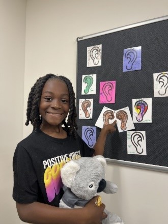 young girl pointing at drawings