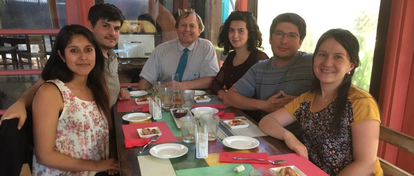 Group of study abroad students and a professor sitting around a table about to eat breakfast