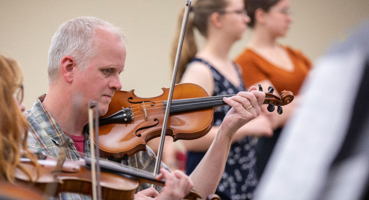 students playing the violin in class