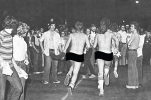 archival image of two men streaking through a crowd