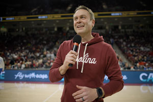 man holding a microphone stands in an arena