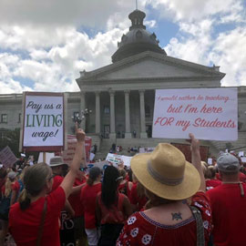 Several people rallying outside of statehouse. 