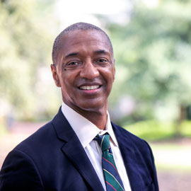 william tate in suit and tie standing outside