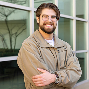 Alex Alpert standing outside in front of a window.