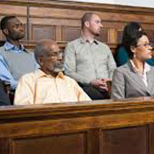 People sitting as a jury in a court room with concerned an interested facial expressions.