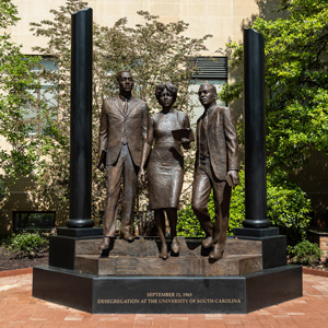 A 12-foot bronze statue of three people stands in front of McKissick Museum.