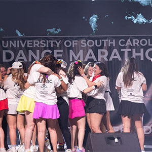 women celebrating on stage at USC Dance Marathon